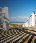 Wooden deck overlooking beach, showcasing deck built with DSVT4MB Deck-Drive DSV Wood Screw 10 x 4 Inch Flat Head T-25.