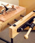 Heavy Duty Carpentry Bench Vise With Manual Threaded Screw For Tightening Workpieces During DIY Cutting Or Sanding And Assembly Projects In Your Workshop on a workbench.