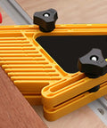 Close-up of a yellow clamp system component on an aluminum T track double cut profile miter slot jig for woodworking workbench.
