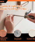 Person using a screwdriver to install white screw from 120 Piece Self Drilling Drywall Anchors And Screws Kit into drywall.