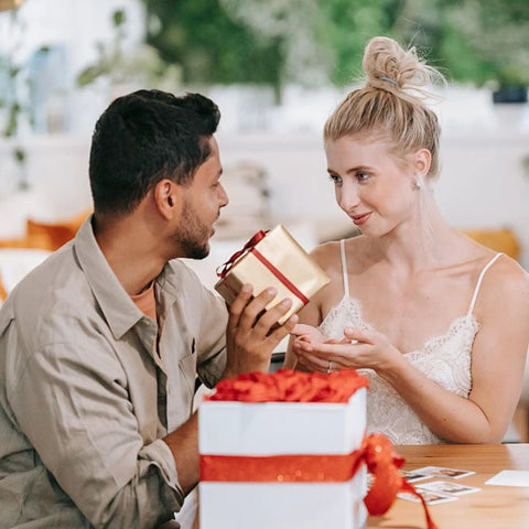 Couple exchanging a gift box, woman wearing Gold Flat Back Stud Earrings Set With 9 Pairs Screw Back Minimalist Everyday Vibe Cartilage Jewelry For Women And Men Hypoallergenic Tiny Studs In Star Heart Moon Ball Disc Designs 3mm 4mm 5mm Sleeper Earring Set