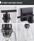 Three Light Black Vanity Lights Over Mirror, detail of metal base, matte black finish, clear glass shades, wall sconce lighting.