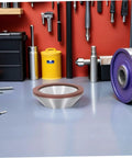 Top Tier Cup Shaped Diamond Grinding Wheel 100mm on workspace with tools and equipment for stone and metal grinding tasks.