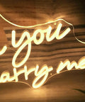 Close-up of warm white LED "Will You Marry Me" neon sign for proposals and weddings, 25 by 15 inches, dimmable wall art decor.