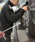Man using Straight Shooter T Handle Socket Wrench Set Forged From Heavy Duty Steel To crack stubborn nuts on a vehicle.
