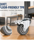 Set Of Four 3 Inch TPR Swivel Plate Casters With Dead Quiet Foot Brakes And Zero Drag Non Marking Rubber Tread For Smooth Home And Garage Mobility close-up of a quiet TPR caster on a wooden surface.