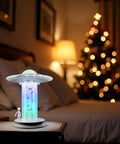 UFO Abduction LED Lamp With Tiny People Figures on bedside table, glowing tractor beam glow, night light, cosmic room decor.