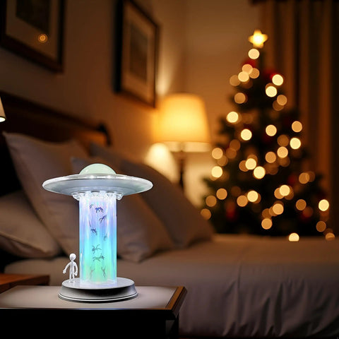 UFO Abduction LED Lamp With Tiny People Figures on bedside table, glowing tractor beam glow, night light, cosmic room decor.