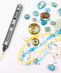 Smooth Operator Mini Electric Drill Pen With Bright Led Torch and Crisp Digital Readout Heavy Duty Aluminum Frame Includes Ten Versatile Bits Compact Rotary Power Driver For Jewelry and Woodcraft Projects Crush Jobs Quick Nail Every Detail on a crafting table with gemstones and beads.