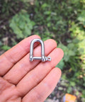 Close-up of a hand holding a 4mm Stainless Steel Mini D Shackle for Paracord Jewelry and Everyday Outdoor Gear, Tough 316 Marine Hardware.