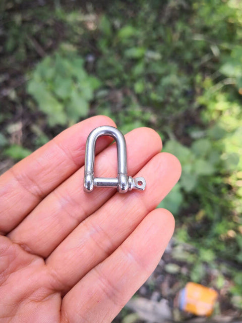 Close-up of a hand holding a 4mm Stainless Steel Mini D Shackle for Paracord Jewelry and Everyday Outdoor Gear, Tough 316 Marine Hardware.