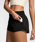 Woman wearing Womens 2.5 Inch Quick Dry Gym Shorts With High Waist And Zip Pockets Built In Liner Breathable Mesh Panels Black XS showing pocket detail.