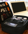 Open Travel Electronics Organizer Case Water Resistant Cable Organizer Bag beside laptop showing organized cables and gadgets