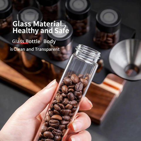 Keep Your Grounds Fresh As A Bell With This Six Tube Single Dose Coffee Bean Storage Jar Set Featuring One Way Exhaust Valves And A Smart Hopper For Flawless 22 To 25 Gram Portions To Brew On Point Daily, showing a glass tube filled with coffee beans.