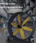 Rugged Heavy Duty Metal Floor Fan Blasting High Velocity Air And Smooth 360 Adjustable Tilt in a warehouse setting.