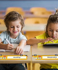 Children with School Bus Themed Desk Name Tags Set With 36 Self Adhesive Name Plates For Classrooms on desks in a classroom.