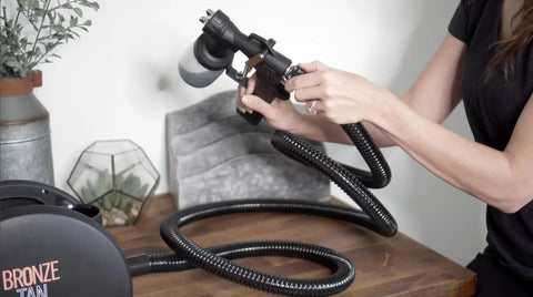 Person holding a Replacement Gun For HVLP Spray Tan Machine With 200ml Cup And Adjustable Flow For DHA Solution