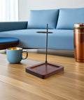 Top Shelf Wood Coffee Dripper Stand Built Tough With Stainless Base on a wooden floor next to a blue cup.