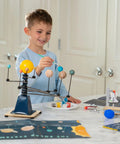 Totally Build It Yourself Space Explorer Kit For Kids Ages Five Plus With Real World Science Lessons Spin A Mini Solar System Build And Launch Model Rockets Paint Space Crafts And Learn How Astronauts Fly. Boy painting solar system model with kid space science kit