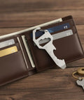 Ultra Slim Metal Multi-Tool Card With Bottle Opener And Hex Wrench For Wallet Or Keychain shown in a brown wallet on wooden surface