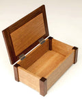 Mini Brass Hinges For Wood Boxes Four Pack Antique Bronze 1 Inch used on an open wooden jewelry box with dark corners.
