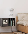 White Outlet Shelf Wall Organizer in living room with smart device, mounted above books on black shelf; outlet shelf holds up to 10lbs.