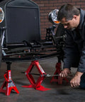 Mechanic using Heavy Duty Steel Scissor Lift Jack 1.5 Ton Car Kit under vintage car for lifting during maintenance