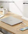 Low Profile Under Cabinet Power Strip With Three Tamper Resistant Outlets And Dual USB A USB C Ports Hardwired Extension Cord White Six Pack on desk with laptop and phone.