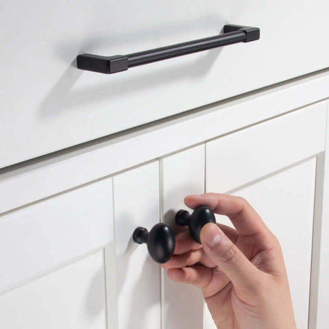 Hand installing Matte Black Cabinet Knobs 10 Pack Solid Zinc Alloy Handles No Fuss Easy Install for kitchen cupboards.