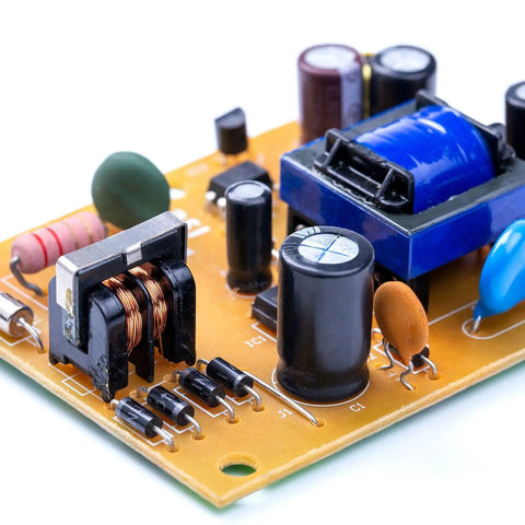 Close-up of an electronic circuit board with various components for DIY electronics and prototyping, featuring a coil and capacitors.