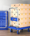 Rock Solid Heavy Duty Folding Platform Truck Rated For One Hundred Fifty Kilos with stacked boxes on a blue cart.