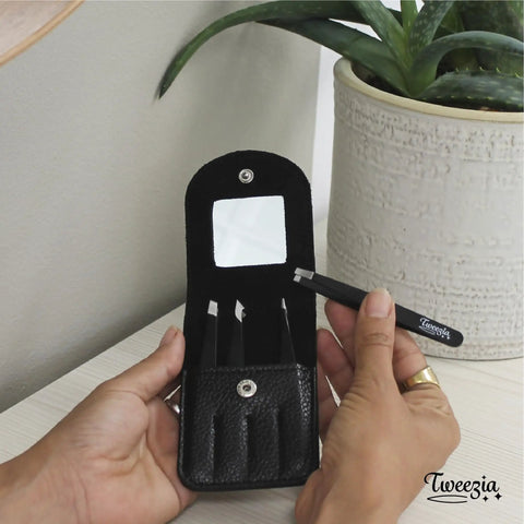 Hand holding Stainless Steel Precision Tweezer Set With Mirror Case Four Piece Kit; classic, slanted tips shown.