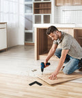 Man drilling wood with Tough As Nails 4 Piece Black L Shaped Stainless Steel Corner Brackets shown on floor