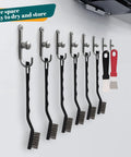15 Piece Mini Stainless Steel Wire Brush Set With Curved Handles For Removing Rust And Welding Slag, Includes 2 Cleaning Scrapers, hanging on wall hooks in a garage or workshop setting.