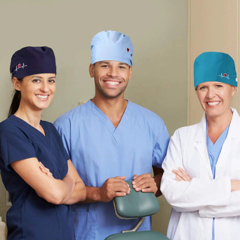 Three medical staff wearing multicolor heart edition scrub caps from 12 Pack Bouffant Scrub Caps Unisex Adjustable Button Hats.