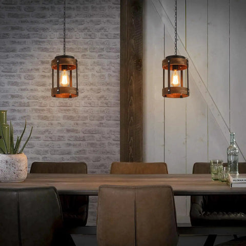 Rustic Farmhouse Pendant Lights Two Pack In Solid Oak And Matte Black Metal Cages With Long Adjustable Chains in a cozy dining setting.