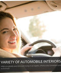 Smiling person driving a car with a focus on the vehicle's interior ceiling and steering wheel.