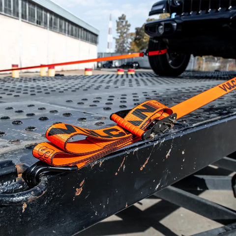 ProSeries Beefy Axle Strap Tie Down Kit With Wire Hook Ratchet Straps securing vehicle on metal trailer bed