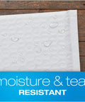Close-up of 6x9 Inch Bubble Mailers Self Seal White Poly Padded Envelopes For Shipping Water Resistant And Air Cushioned Protection Easy Peel Closure 50 Pack For Online Sellers And Home Biz with water droplets showing moisture resistance on wood surface