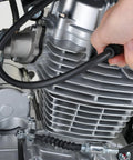 Silicone vacuum hose for automotive use; hand holding black hose attached to a metal engine cylinder.