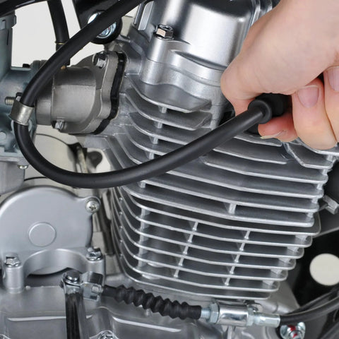 Silicone vacuum hose for automotive use; hand holding black hose attached to a metal engine cylinder.