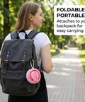 A woman carrying a backpack with a pink Foldable Water Bottle With Leak Proof Locking Lid For Outdoor Adventures attached.