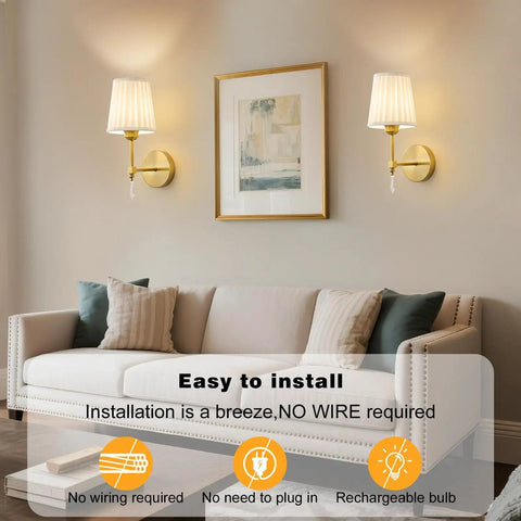 Gold Cordless Wall Sconces Set Of Two Battery Operated Rechargeable Dimmable Led Lamps With Fabric Shades on a living room wall.