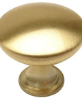 Close-up of a single knob from the 25 Pack Brushed Brass Round Solid Cabinet Knobs 1-1/4 Inch Diameter, Classic Vibe With 1 Inch Mounting Screws Included.