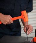 Person using 1 Lb Neon Orange Dead Blow Hammer With Unibody Molded Body And Checkered Grip, Spark And Rebound Resistant