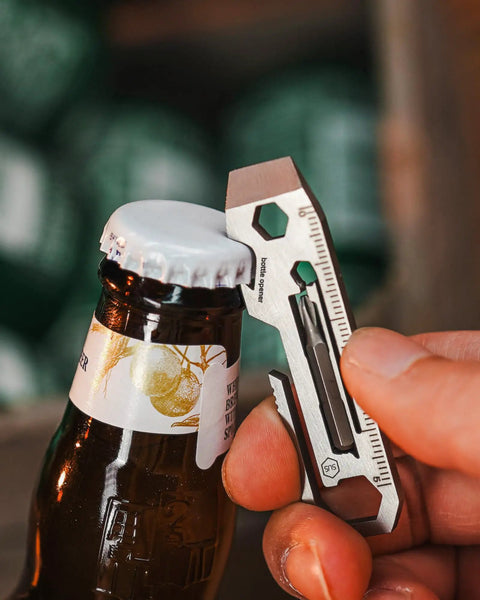 KR03 EDC Pry Bar Multitool With Flathead And Phillips Driver, Bottle Opener, Three Hex Wrenches, Built In Metric And Imperial Ruler in use opening a bottle