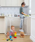 Adjustable 29.5 To 53 Inch Wide Baby Gate For Doors And Stairs, 30 Inch Tall, pressure-mounted white gate in kitchen doorway