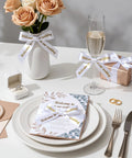 Pretty Slick Portable Label Maker With Bluetooth Pairing And Durable Mono Ribbon Tape For Totally Neat Home Desks And Dorms Super Pocket Sized Sticker Creator displayed with wedding decor like flowers, invitations, and champagne.