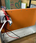 Orange phenolic sheet insulation plate mounted inside a metal frame, used for zero clearance inserts and throat plates test jigs.