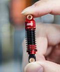 Threaded Shock Absorber Oil Damper 53mm for Redcat Ascent18 held by hand showcasing red CNC machined aluminum body